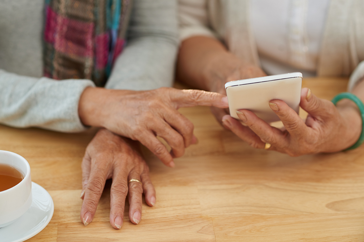 Пожилые женщины держат в руках смартфон